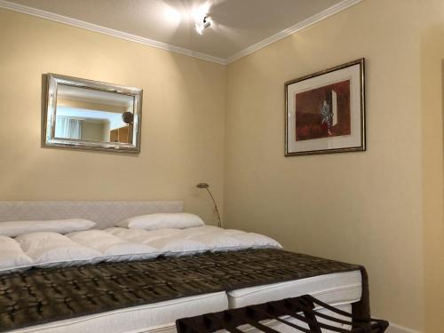 Schlafzimmer mit einem Bett und einem Wandspiegel in der Unterkunft Ferienwohnung in weißer Villa am Kliff in Flensburg