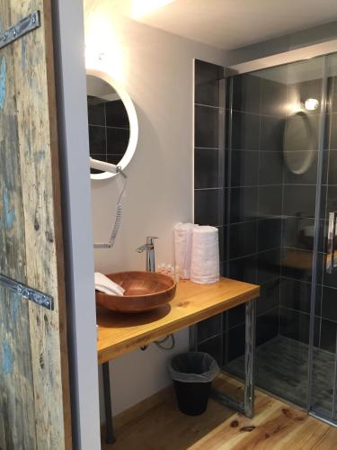 a bathroom with a sink and a shower at Logis Hôtel O Lodge in Cleppé