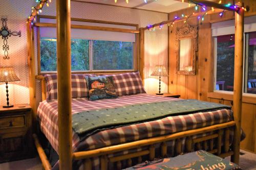 a bedroom with a four poster bed with christmas lights at Dream Getaway with Secluded Spa in Big Bear Lake