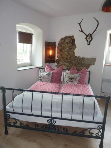 een slaapkamer met een bed met roze dekens en kussens bij Fahrenbach-Alm in Tröstau
