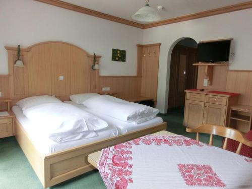 a bedroom with two beds and a flat screen tv at Gästehaus Hollerer in Gerlos