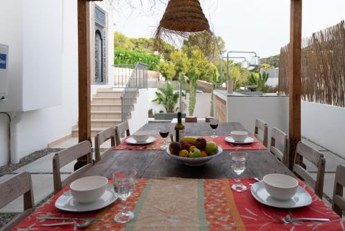 a wooden table with a bowl of fruit on a balcony at Casa Aguila Ibiza in Cala Vadella