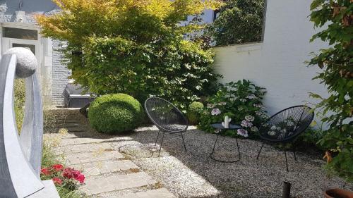 two chairs and a table in a garden at B&B The Street Lodge in Liège