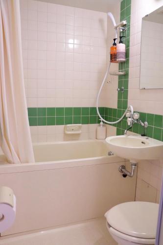 a bathroom with a tub and a sink and a toilet at Guesthouse All you need - All rooms have an ocean view! in Shimoda