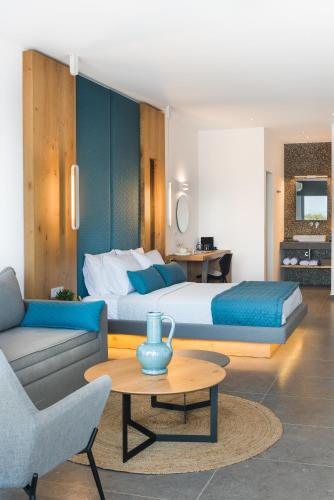 a bedroom with a bed and a couch and a table at Volcanic Arc Suites in Oia