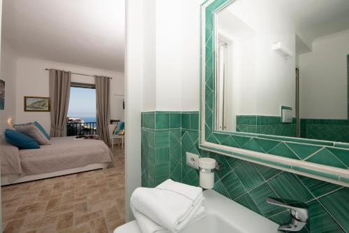 a bathroom with a sink and a mirror and a bed at Amalfi Casamia B&B in Amalfi