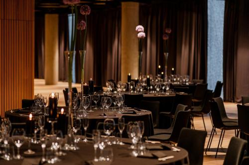 a room filled with tables and chairs with wine glasses at Nobu Hotel Warsaw in Warsaw