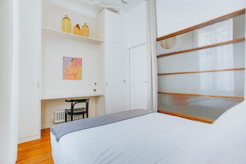 une chambre avec un lit blanc et une fenêtre dans l'établissement Joie Paris Arc de Triomphe - Champs Elysée, à Paris