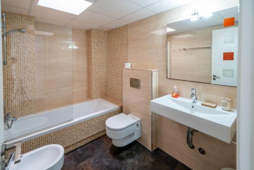 a bathroom with a sink and a toilet and a bath tub at Casa Aguila Ibiza in Cala Vadella