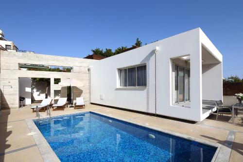 une villa avec une piscine et une maison dans l'établissement Paradise Cove Luxurious Beach Villas, à Paphos