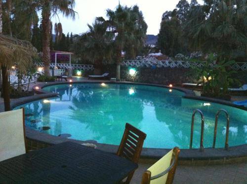 a swimming pool at night with a table and chairs at Hotel Al Togo Fitness & Relax in Vulcano