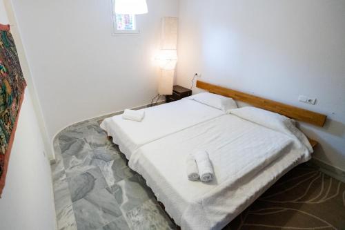 a small white bed in a room with a lamp at Casa Aguila Ibiza in Cala Vadella