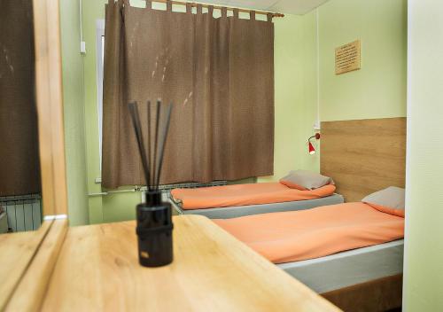 トゥーラにあるМини-отель Клуб путешественниковのベッド2台、テーブル(ランプ付)が備わる客室です。
