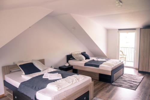 two beds in a room with a attic at La Ferma Nagy in Vişeu de Sus