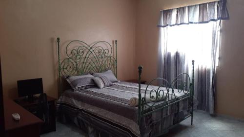 a bedroom with a bed and a window at Nicole's Guest Home in Higuey