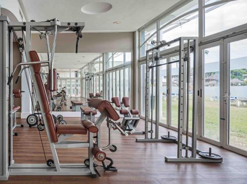 a gym with treadmills and ellipticals and windows at Ilunion Islantilla in Islantilla