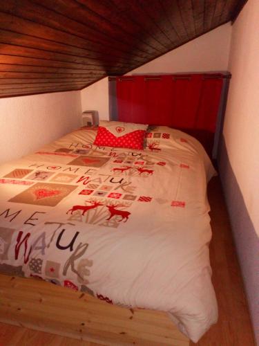 a bedroom with a bed with a red head board at appartement en chalet au pied des pistes in La Norma