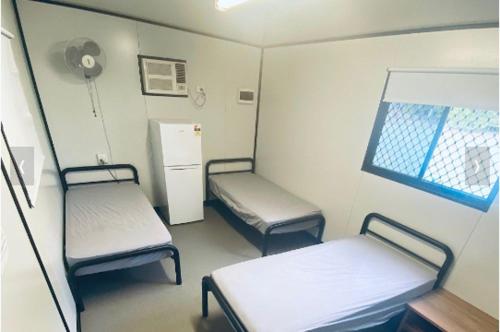 um quarto de hospital com duas camas e um frigorífico em Lions Camp Kanga em Dittmer