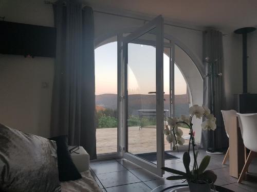 a room with a glass door with a view of a deck at La Ferme Du Levant in Gérardmer