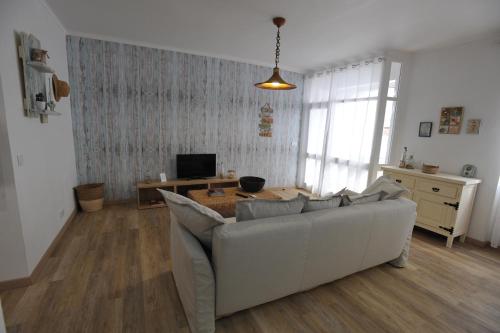 a living room with a white couch and a television at Lagos Central Apartments Ap 1 in Lagos