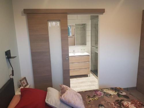 a bathroom with a bed and a sink and a mirror at La Ferme Du Levant in Gérardmer