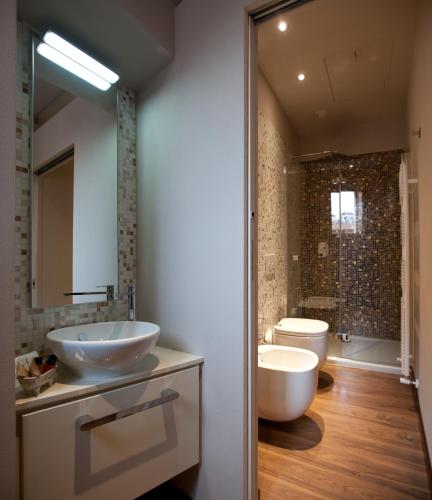 a bathroom with two sinks and a tub and a toilet at Vinoteca La Sacrestia in Alba