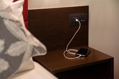 a black ipod plugged into an outlet on a table at Hotel Palarine in Erts