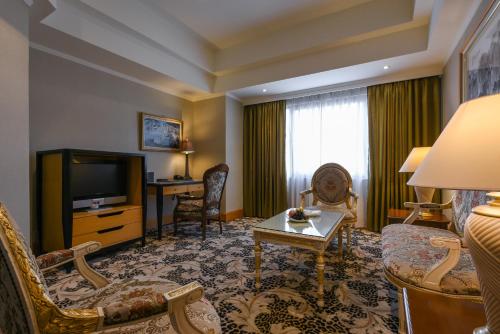 a living room with a couch and a tv in a hotel room at THE LEES Hotel in Kaohsiung