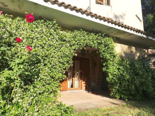 an entrance to a house with roses growing around it at Villa in Toscana a due passi da Saturnia in San Giovanni delle Contee