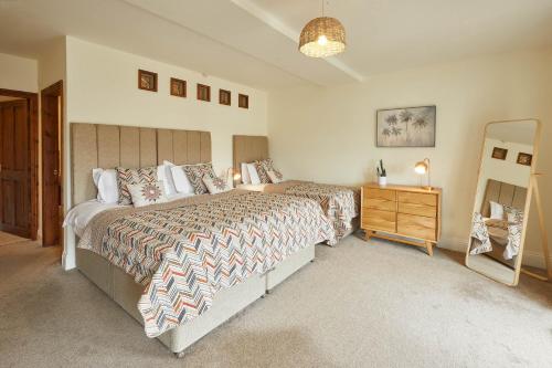 a bedroom with two beds and a dresser and a mirror at Host & Stay - Harbour View House in Whitby
