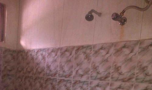 W łazience znajduje się prysznic i marmurowa wanna. w obiekcie Hotel Om Shiv Shankar w mieście Uttarkāshi