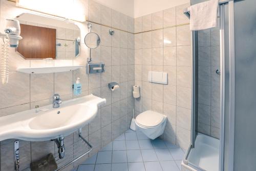 ein Bad mit einem Waschbecken, einem WC und einer Dusche in der Unterkunft Hotel Allmer in Bad Gleichenberg