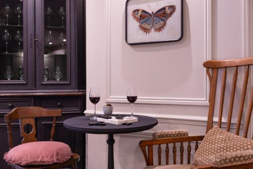 a table with two glasses of wine and a butterfly on the wall at Hotel Touraine Opera in Paris