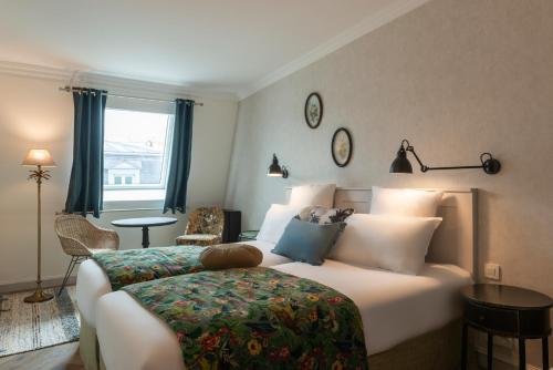 a hotel room with a bed and a window at Hotel Touraine Opera in Paris