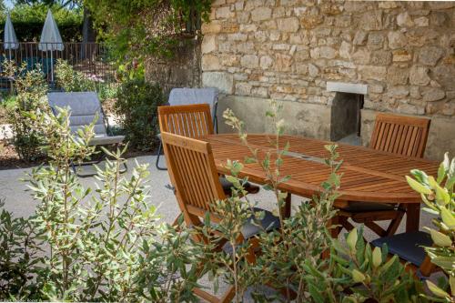 a wooden table and chairs in a garden at Mas des Cèdres in Ménerbes