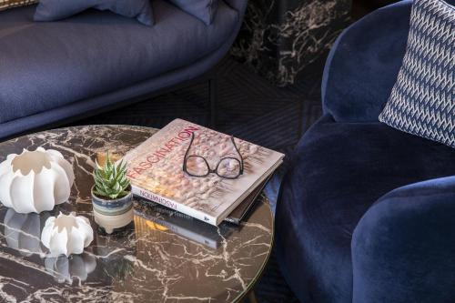 a book and glasses on a table next to a couch at Hôtel Elysées Régencia in Paris