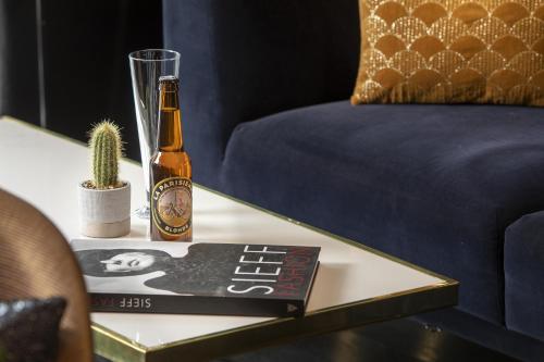 a bottle of beer on a table next to a cactus at Hôtel Elysées Régencia in Paris