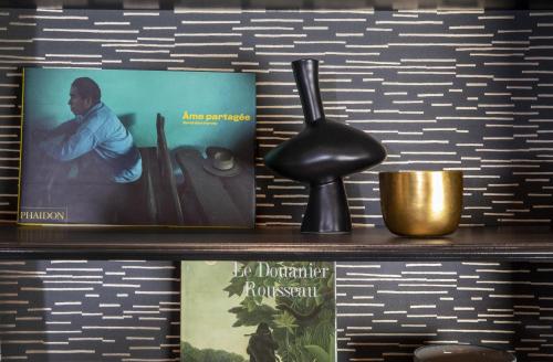 a shelf with two books and a lamp and a book at Hôtel Elysées Régencia in Paris