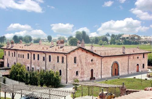 un gran edificio de ladrillo con un campo en el fondo en Corte Breda, Agriturismo Bed&Breakfast, en Chiari