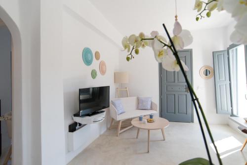 a white living room with a white couch and a table at LAGADI SUITES by K&K in Mesaria