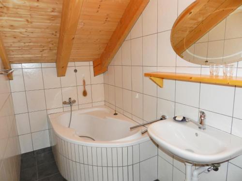 La salle de bains est pourvue d'une baignoire et d'un lavabo. dans l'établissement Charmante Ferienwohnung im Landhausstil, à Kašperské Hory