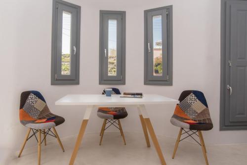 a table and two chairs in a room with windows at LAGADI SUITES by K&K in Mesaria