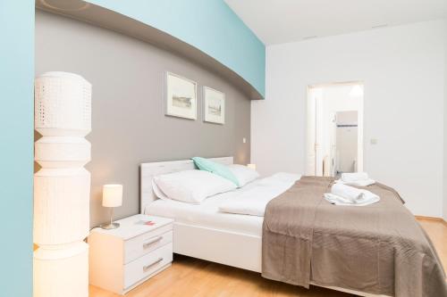 a white bedroom with a bed and a window at Stephansdom Premium Apartments in Vienna