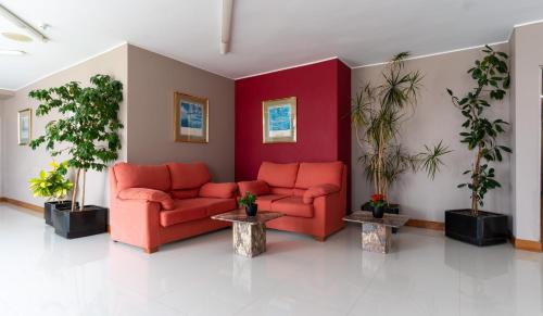 a lobby with two red couches and potted plants at Chateau La Roca in Sancibrián