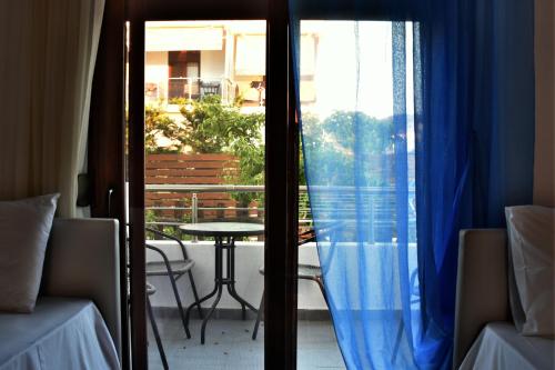 a view of a patio with a table and a window at Theano Studios in Paralia Sikias