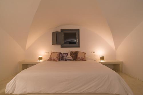 a bedroom with a large white bed with two lamps at LAGADI SUITES by K&K in Mesaria