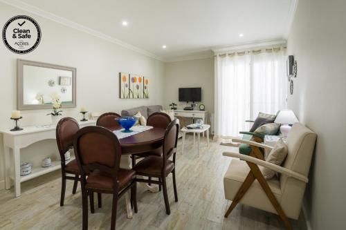a dining room and living room with a table and chairs at Canadian Villa in Ponta Delgada