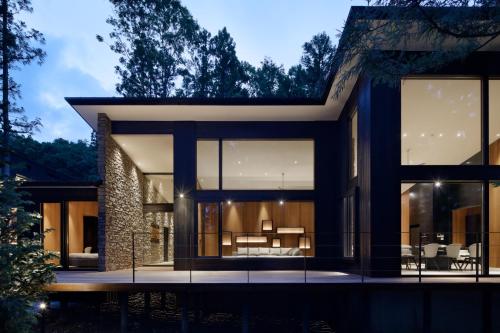 a modern house with glass doors and windows at Villa El Cielo Hakuba in Hakuba