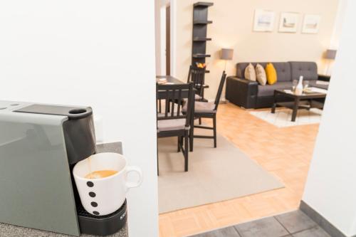 a cup of coffee is in a refrigerator in a living room at Stephansdom Premium Apartments in Vienna