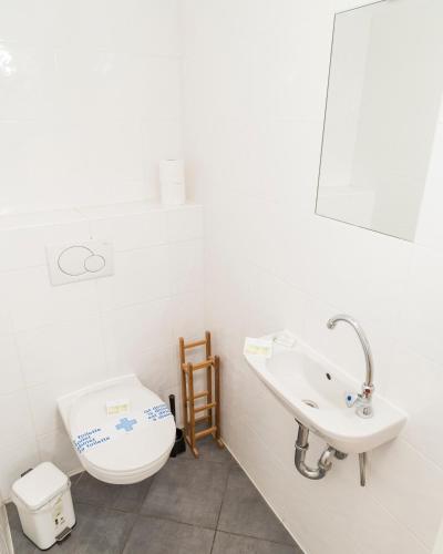 a white bathroom with a toilet and a sink at Stephansdom Premium Apartments in Vienna